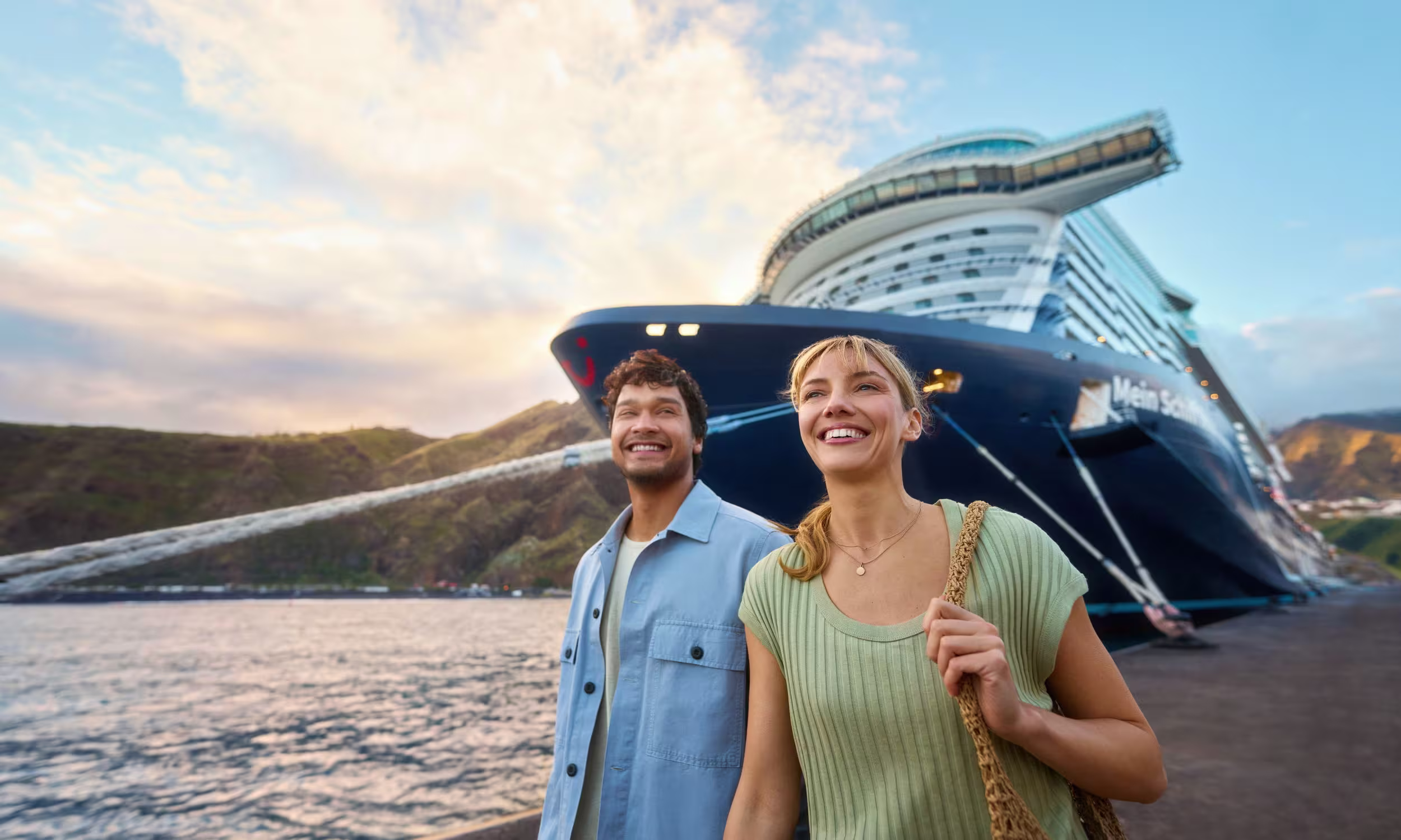Ein Paar vor einem Mein Schiff Kreuzfahrtschiff